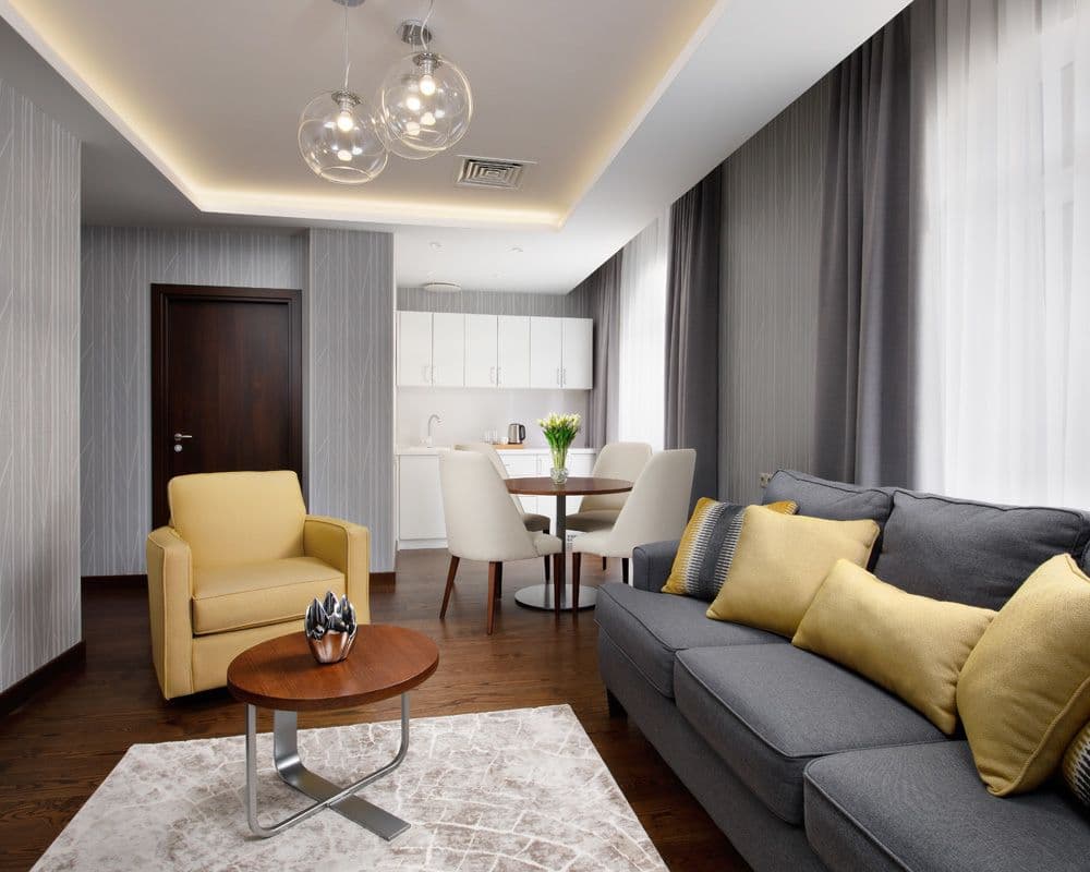 Современный и уютный номер санатория с мягкой мебелью, стильным интерьером и обеденной зоной.