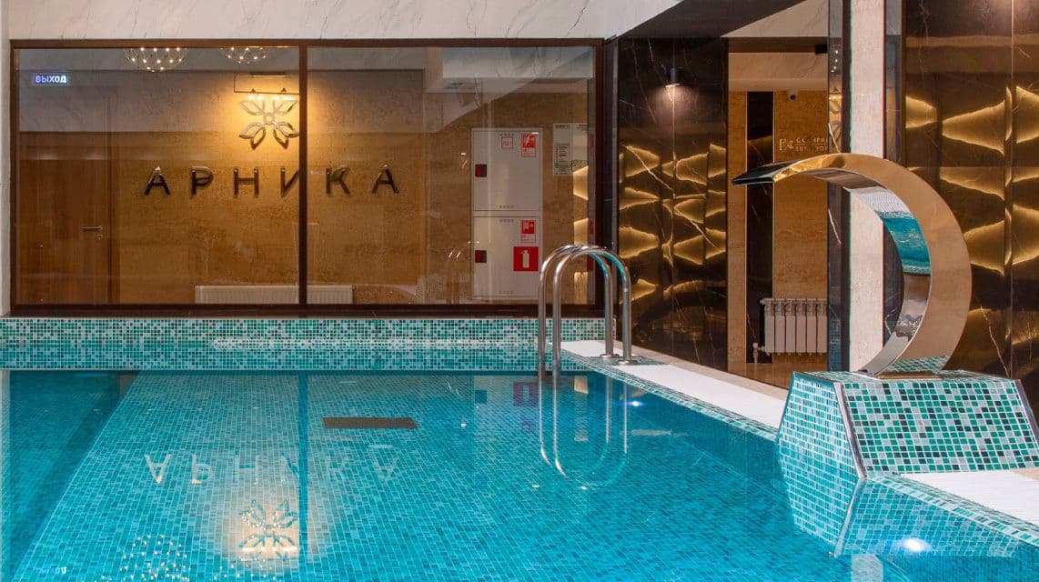 Закрытый бассейн санатория с современной подсветкой и удобными зонами отдыха.